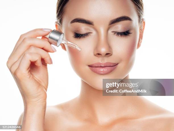 beautiful girl getting skin anti aging treatment - face oil stock pictures, royalty-free photos & images