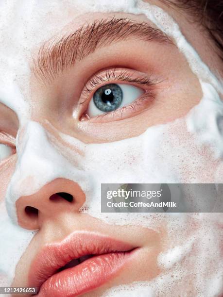 belle femme appliquant la mousse de nettoyage sur la peau - exfoliant photos et images de collection