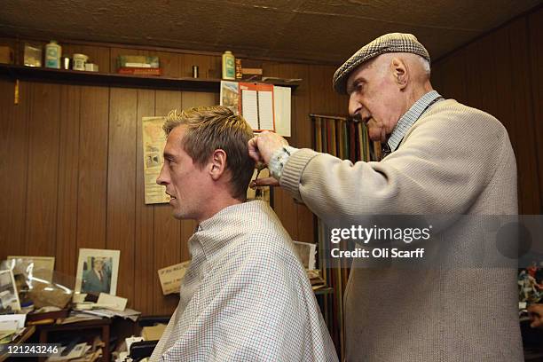 Year-old Aaron Biber cuts the hair of his favorite footballer Peter Crouch in his hairdressing salon which was damaged during the riots on Tottenham...