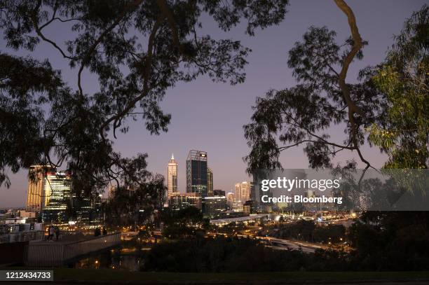 Buildings stand illuminated at dusk in Perth, Australia, on Saturday, May 9, 2020. Australia plans to reopen its crippled economy by July as its...