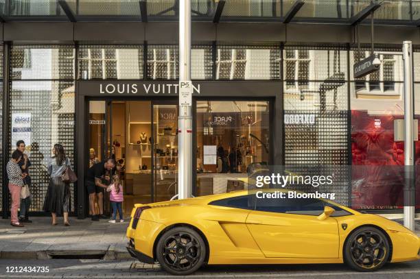 Customers stand in line outside a Louis Vuitton store, operated by LVHM Moet Hennessy Louis Vuitton SE, during a partial lockdown imposed due to the...