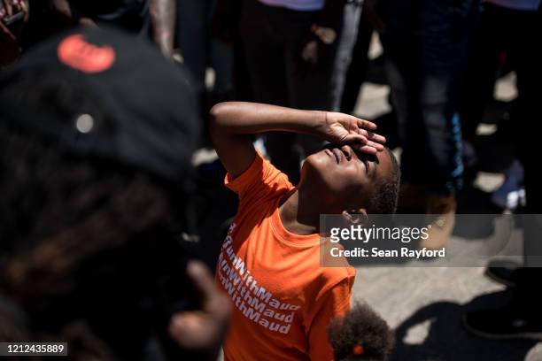 Young boy looks up at the sun as people gather to honor the life of Ahmaud Arbery at Sidney Lanier Park on May 9, 2020 in Brunswick, Georgia. Arbery...