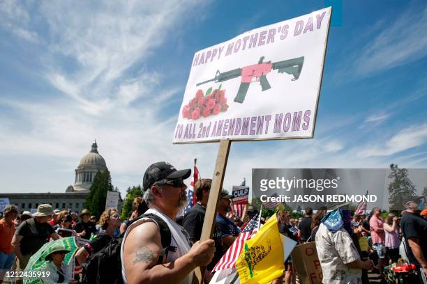 Mike Ladines of Covington, Washington, holds a Mother's Day themed pro-gun sign as people protest against the stay-at-home order outside the State...