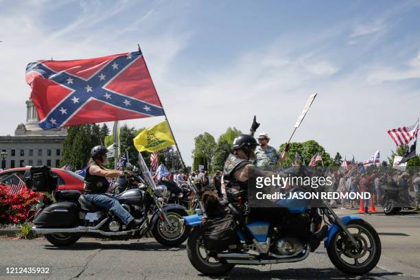 Motorcyclist flies a Confederate flag while showing support during a protest outside the State Capitol in Olympia, Washington on May 9, 2020. - The...