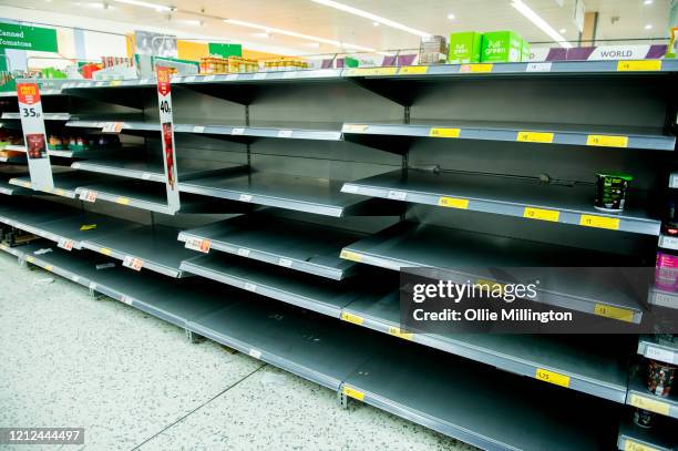 Consumers leave shelves empty in a London Morrisons store as panic-buying over coronavirus continues on March 14, 2020 in London England. Members of...