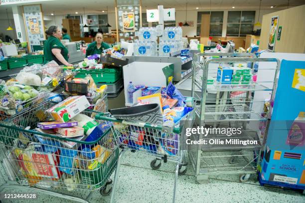 Workers collect items to restock the empty shelves in a London Morrisons store as panic-buying over coronavirus continues on March 14, 2020 in London...