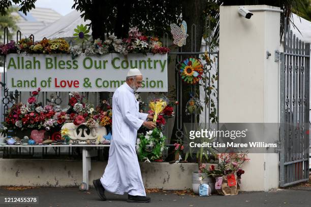 Muslim man adjusts flowers at the entrance of the Masjid An-Nur mosque on March 15, 2020 in Christchurch, New Zealand. 51 people were killed and...