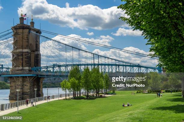 People gather at Smale Riverfront Park near the Roebling Suspension Bridge near the Ohio River in the wake of the Coronavirus COVID-19 pandemic, on...