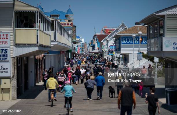 People walk on the boardwalk as the area re-opens from the coronavirus pandemic on May 10, 2020 in Ocean City, Maryland. A popular summer tourist...