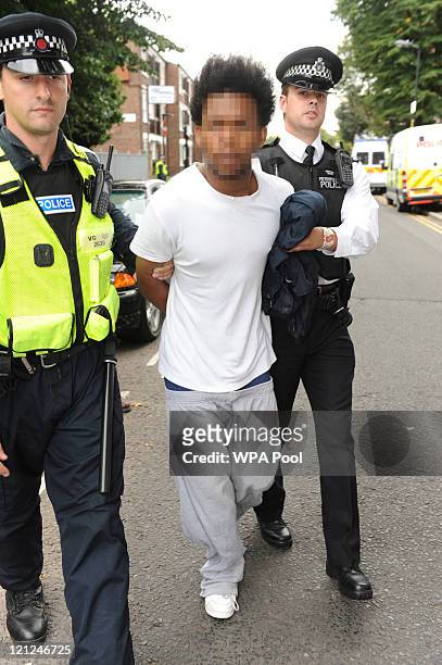 Year-old man is led away by police officers after being arrested and evidence seized from a property in Clarence Road, Hackney in conjunction with...