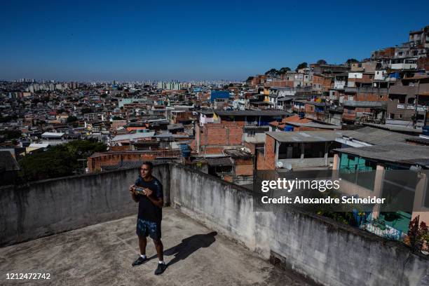 Ivan Pereira do Nascimento, 39 years old, conducts training sessions from the roof of his house to residents of Brasilandia amidst the coronavirus...