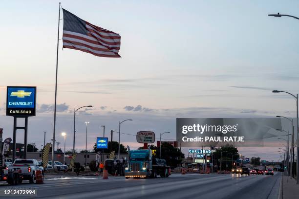 Semi-truck drives down one of the major streets on May 7, 2020 in Carlsbad, New Mexico. - Carlsbad was once a town whose main industry was mining...