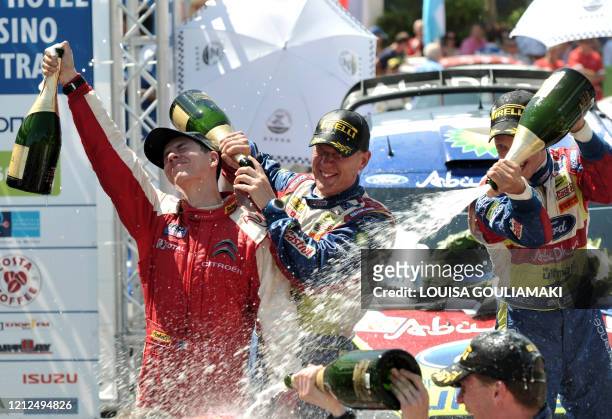 Julien Ingrassia, Jarmo Lehtinen and Mikko Hirvonen spray champagne on each other during the awards ceremony of the WRC Acropolis Rally in Greece in...