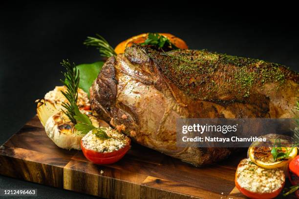 roasted leg of lamb with vegetable and herbs - stock photo - roast lamb stock pictures, royalty-free photos & images