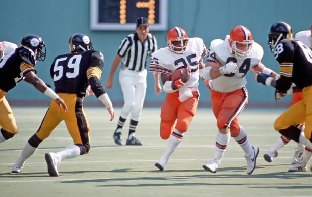 Running back Charles White of the Cleveland Browns runs behind the blocking of offensive lineman Joe DeLamielleure as linebackers Jack Ham and Jack...