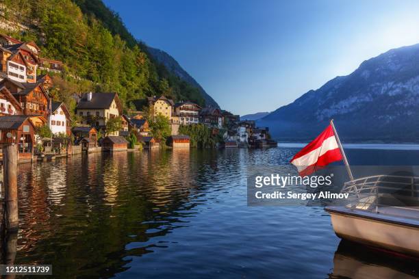 hallstätter see landscape and fragment of boat with austrian flag - austria flag stock pictures, royalty-free photos & images