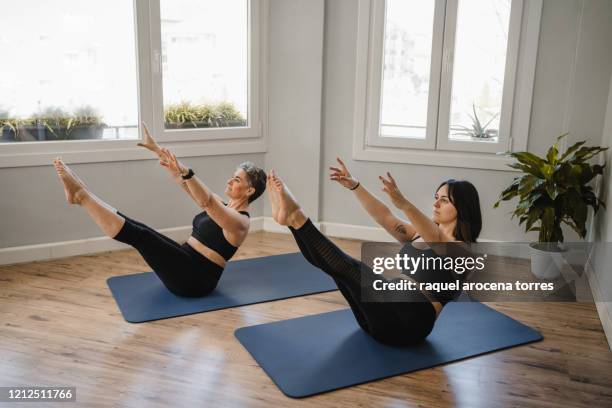 two women of different ages practicing pilates on a mat - mat stock pictures, royalty-free photos & images