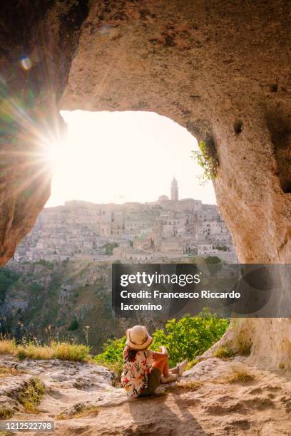 woman tourist admiring the view of matera at sunset. murgia belvedere, basilicata, italy - bari stockfoto's en -beelden