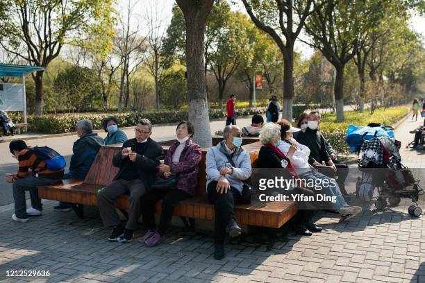 Tourists wear protective masks at Gucun Park on March 15, 2020 in Shanghai, China. More Shanghai parks have reopened starting Friday as health...