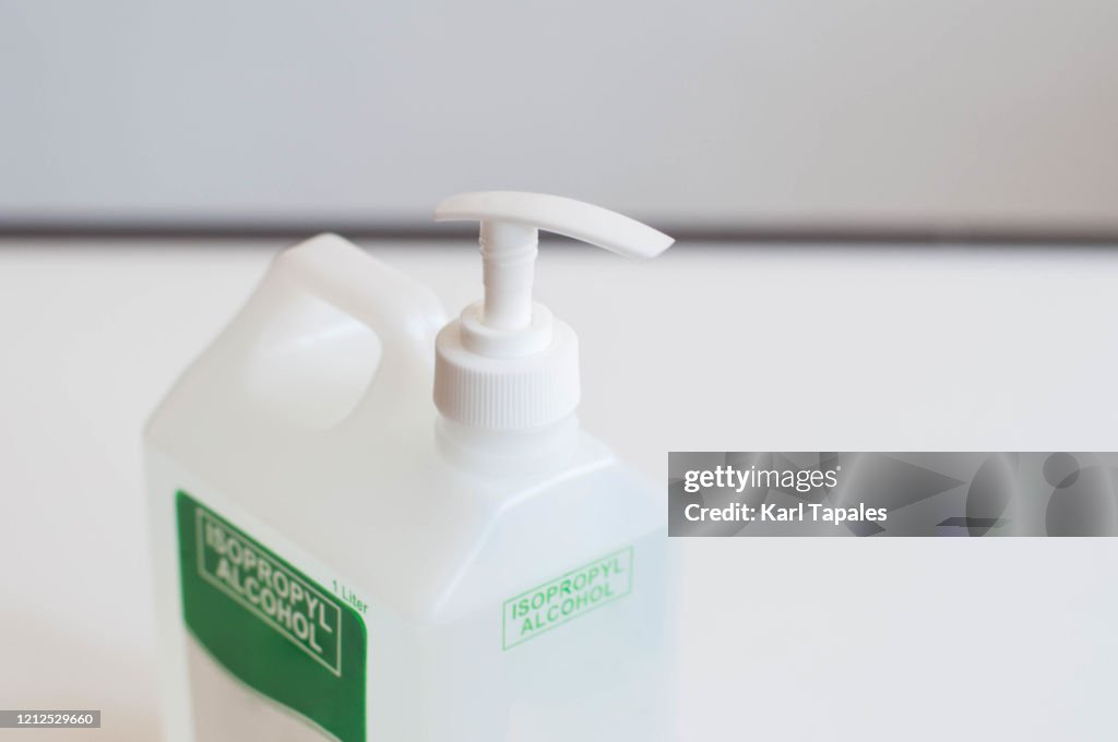 A still life of isopropyl alcohol on a plastic dispenser