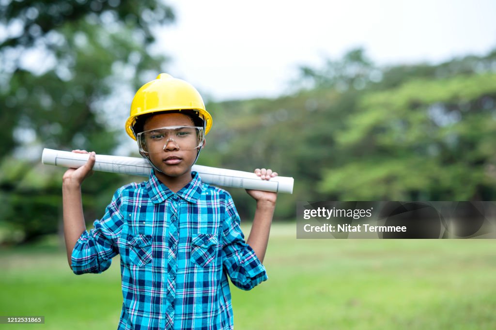 Little Genius Engineer. Little Afro boy in the construction helmet holding a blueprint. Dream occupation, Child, Learning concept.