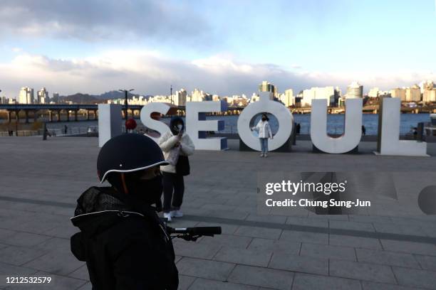 People wear a mask to protect themself from the coronavirus at the Han River park on March 15, 2020 in Seoul, South Korea. According to the Korea...