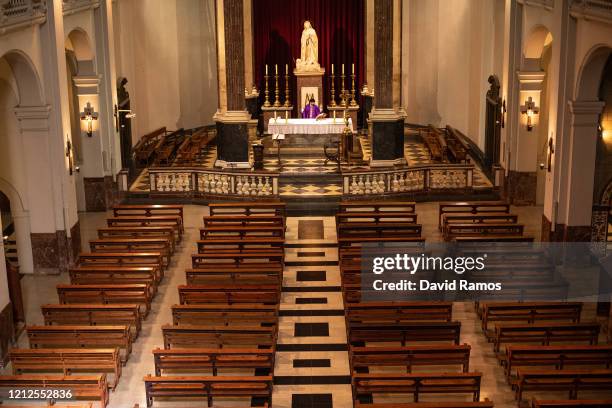 Priest Carlos Enrique Leal offers the Mass in an empty church as it is being broadcasted in streaming via a Youtube channel to its parishioner at the...