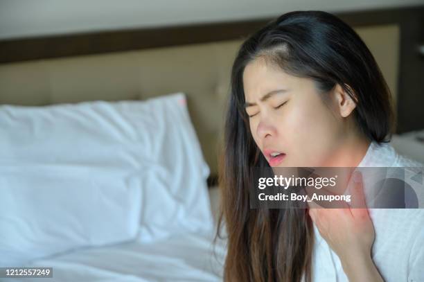 close-up of woman having sore throat or throat pain. - throat stock pictures, royalty-free photos & images