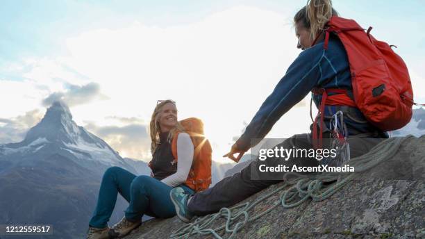 female mountaineers chat and smile from mountain peak - summit day 2 stock pictures, royalty-free photos & images