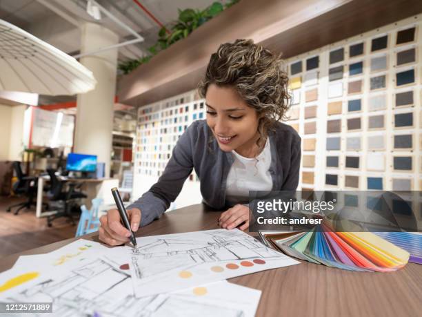interior designer drawing sketches while shopping at a furniture store - showcase imagens e fotografias de stock