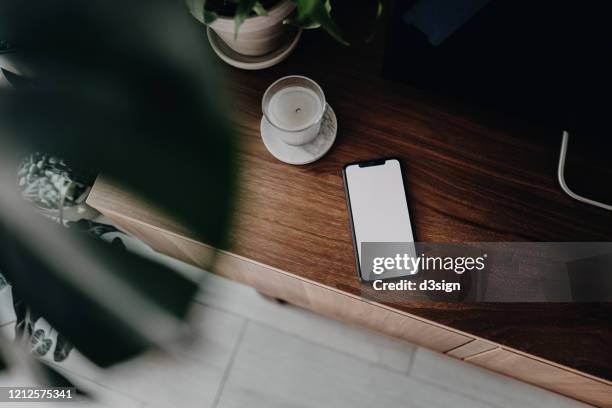 directly above shot of a smartphone on wooden cabinet in the living room - phone on table stock pictures, royalty-free photos & images