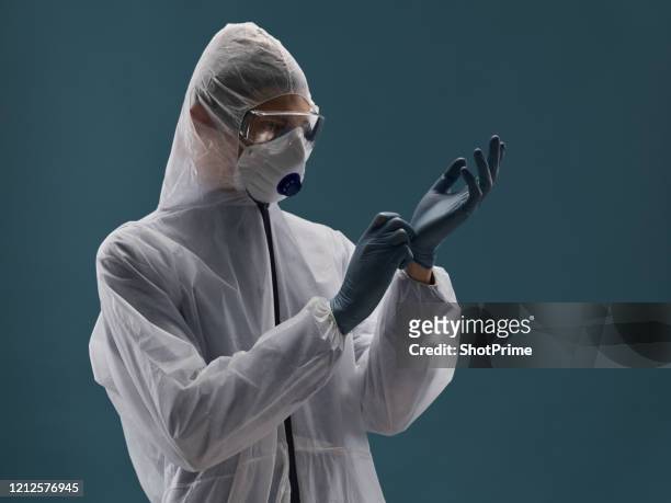 a medical professional in an antiplague suit is fully protected from the virus and wear sterile rubber gloves. - pandemic illness photos et images de collection