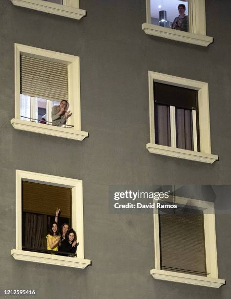 People applaud from a balcony during a flash mob called through social media and messaging platforms, aimed to thank workers in the fight against...