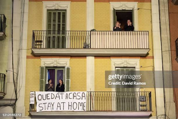 People applaud from a balcony during a flash mob called through social media and messaging platforms, aimed to thank workers in the fight against...