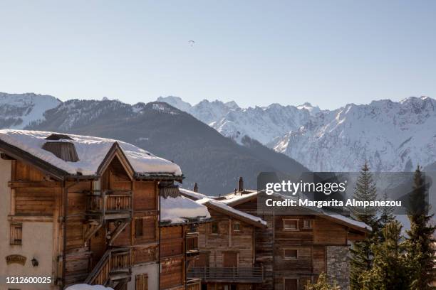 roofs covered in snow and mountains in the background - verbier fotografías e imágenes de stock