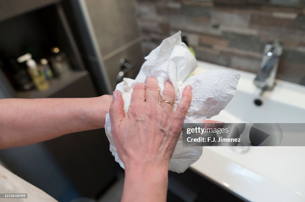 Close-up of woman drying her hands with paper