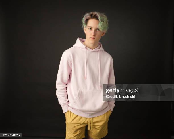 verticale de studio d’un garçon d’adolescent avec le cheveu vert sur un fond noir - short hair photos et images de collection
