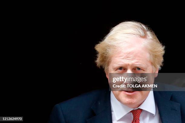Britain's Prime Minister Boris Johnson reacts as he leaves from 10 Downing Street in central London on May 11 to head to the House of Commons where...