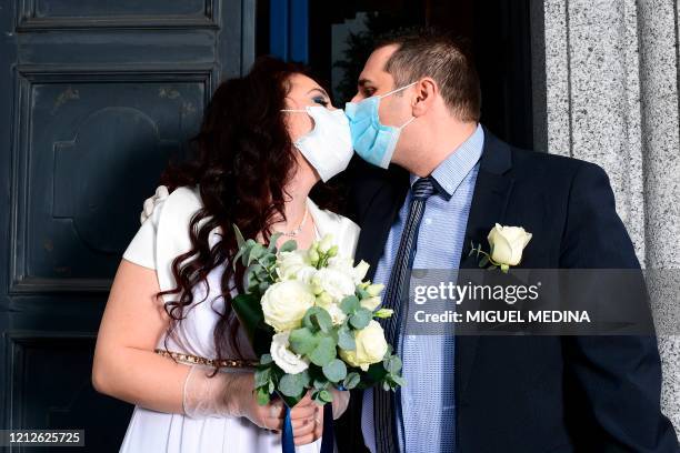 Newly-wed Italians Ester Concilio and Rafaele Carbonelli kiss while wearing face masks following their wedding ceremony at the Briosco's town hall,...