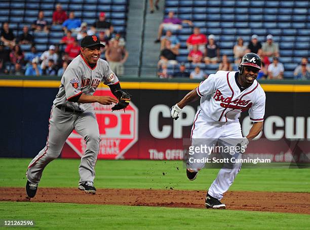 Michael Bourn of the Atlanta Braves gets caught in a rundown with Orlando Cabrera of the San Francisco Giants at Turner Field on August 16, 2011 in...