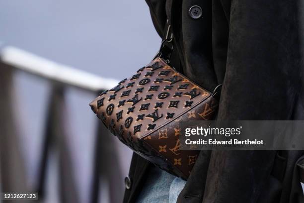 Passerby wears a brown Vuitton monogram bag, in the streets of Paris, on March 15, 2020 in Paris, France.