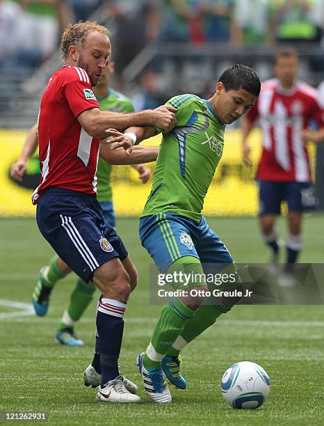 Fredy Montero of the Seattle Sounders FC battles Simon Elliott of Chivas USA at CenturyLink Field on August 13, 2011 in Seattle, Washington.