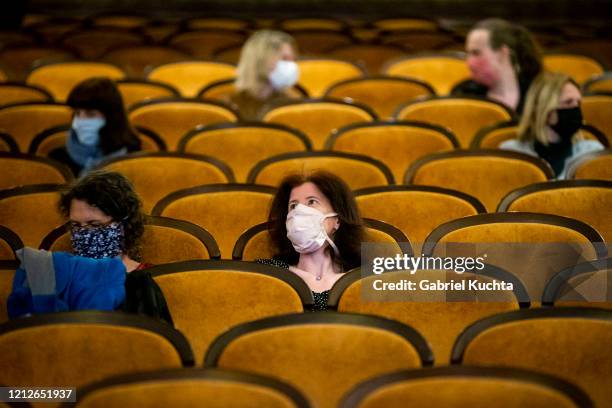 Customers wearing protective masks sit apart in observance of social distancing measures inside a movie theater as the Czech government lifted more...