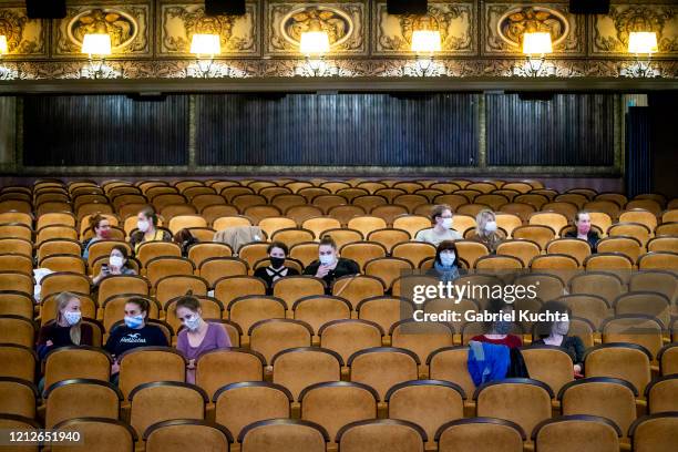 Customers wearing protective masks sit apart in observance of social distancing measures inside a movie theater as the Czech government lifted more...