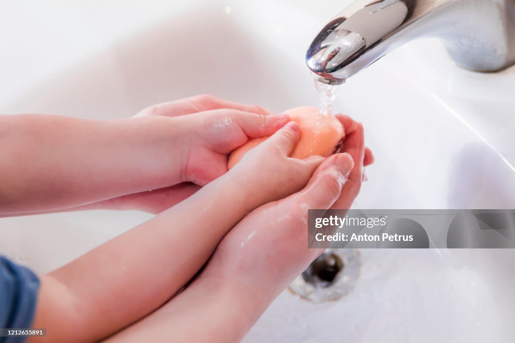 Mom teaches little daughter to wash her hands