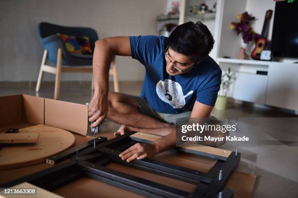 man assembling furniture at home - assembling furniture stock pictures, royalty-free photos & images