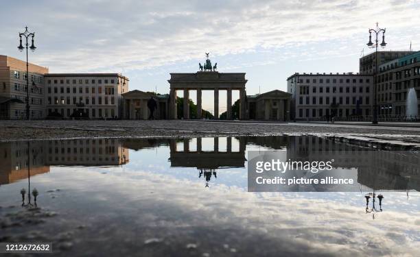 The Brandenburg Gate is reflected in a puddle of rain. Photo: Annette Riedl/dpa