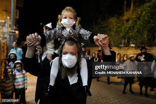 Ultra-Orthodox Jews wearing masks against the Covid-19 coronavirus gather for a Lag BaOmer bonfire in Jerusalem's religious Mea Shearim neighbourhood...