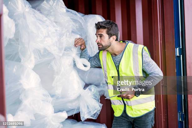 male inspector examining stock in cargo container - funcionário de alfândega imagens e fotografias de stock