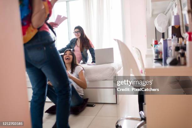 excited teenage girls as friend arrives with concert tickets - concert ticket stock pictures, royalty-free photos & images